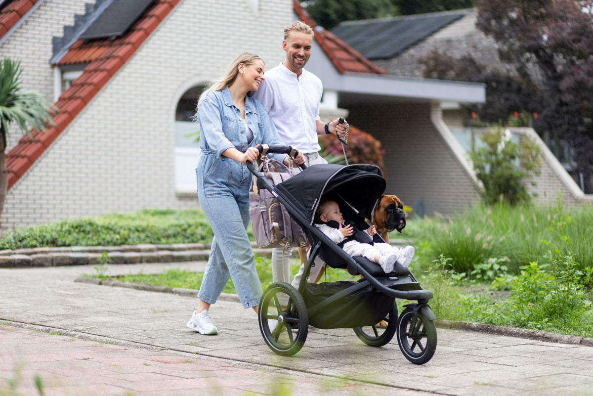 Ouders wandelen samen met hun kindje en genieten van tijd met elkaar dankzij Youha